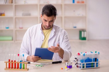 Young chemist sitting at the lab