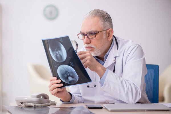 Old doctor radiologist working at the hospital