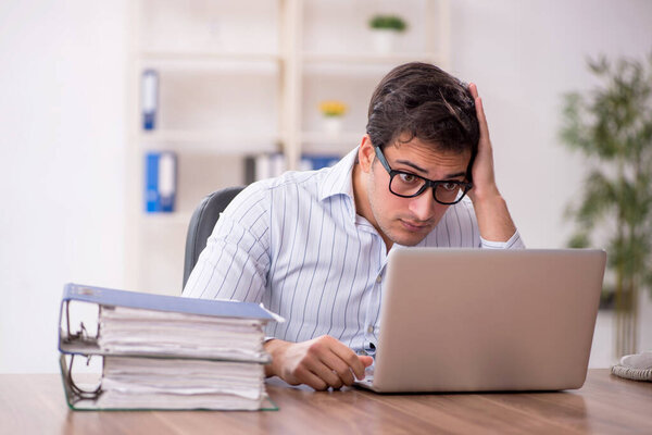 Молодой бизнесмен и слишком много работы на работе
