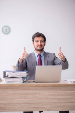 Genç işadamı işyerinde oturuyor.