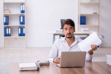 Genç işadamı ve ofiste çok fazla iş var.