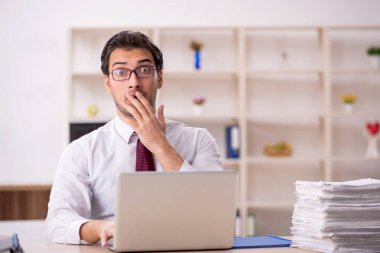 Genç işadamı ve işyerinde çok fazla iş var.