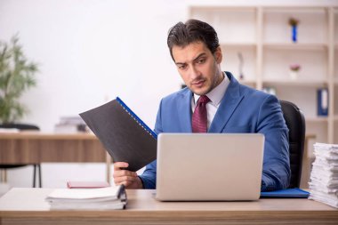 Genç işadamı ve işyerinde çok fazla iş var.