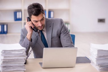 Young employee and too much work at workplace