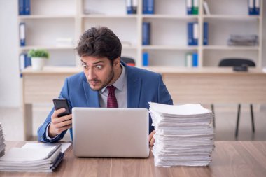 Young employee and too much work at workplace