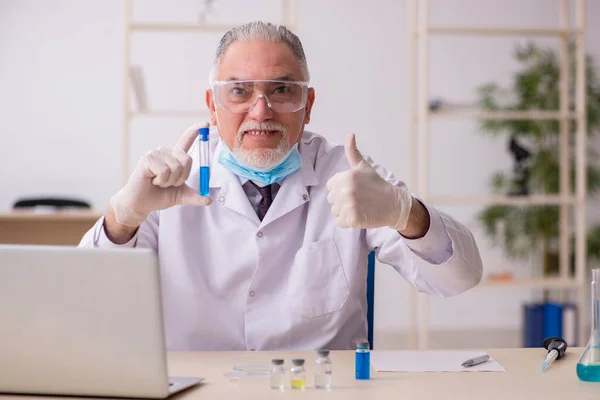 Old chemist working in the lab during pandemic