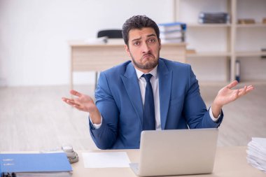 Genç işadamı ve işyerinde çok fazla iş var.