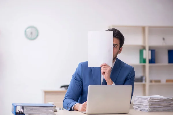 stock image Young businessman employee and too much work at workplace