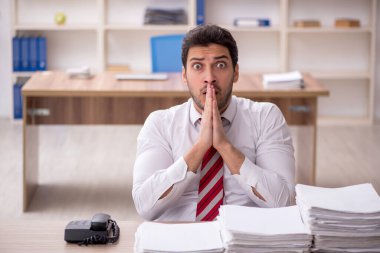 Genç işadamı ve işyerinde çok fazla iş var.