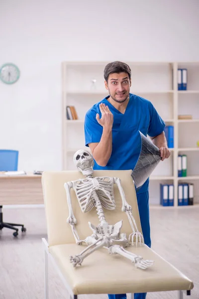 診療所の若い医師の放射線技師と骨格患者 — ストック写真