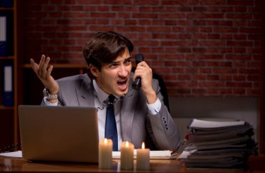 İş adamı mum ışığında geç saatlere kadar çalışıyor.