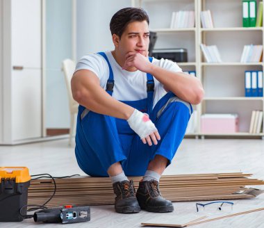 Zemin kaplamalarında çalışan genç işçi.