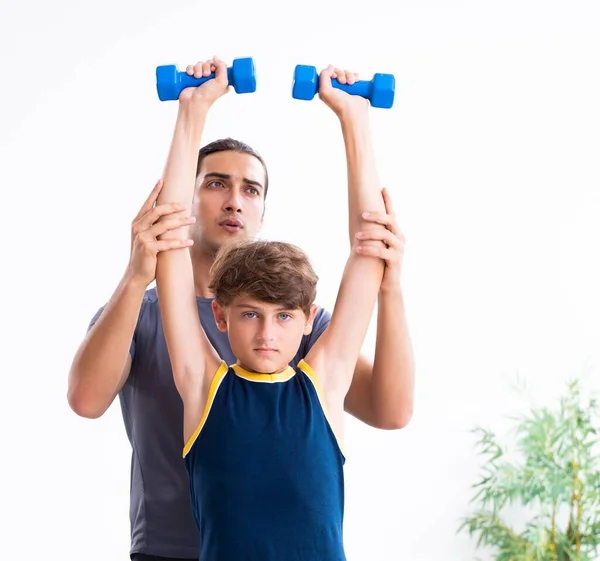 stock image The young father and his son doing exercises