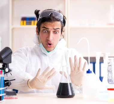 Laboratuvarda çalışan genç yakışıklı kimyager.