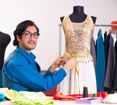 Atölyede çalışan genç erkek terzi.