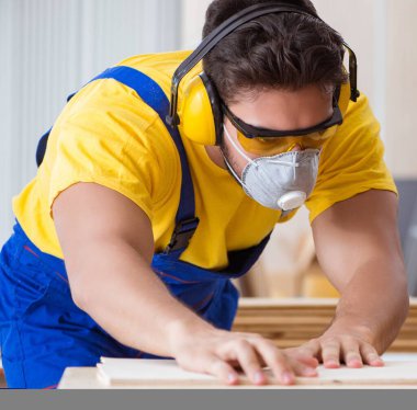 Daire testere ile çalışan genç marangoz.