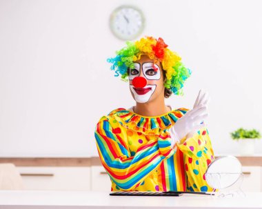 Erkek palyaço evde performansa hazırlanıyor.