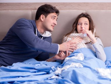 Evde, yatakta hasta kocayla ilgilenen kadın.