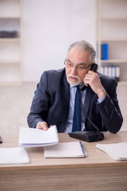 Old employee working at workplace