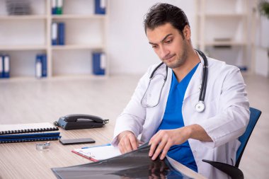 Genç erkek doktor radyoloji uzmanı hastanede çalışıyor.