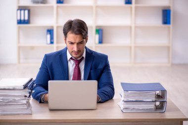 Genç işadamı ve işyerinde çok fazla iş var.