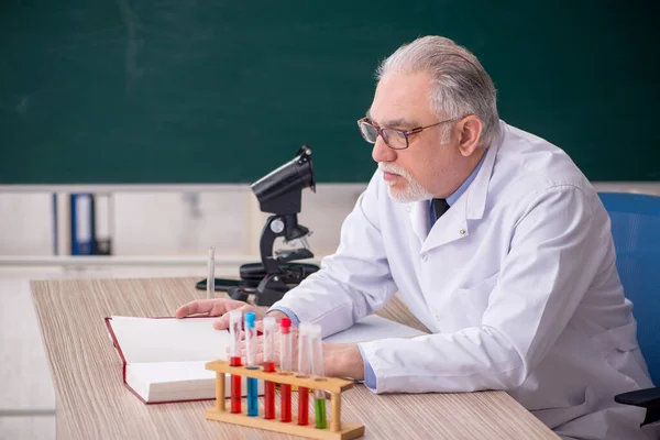 教室に座っている古い化学者の先生 — ストック写真
