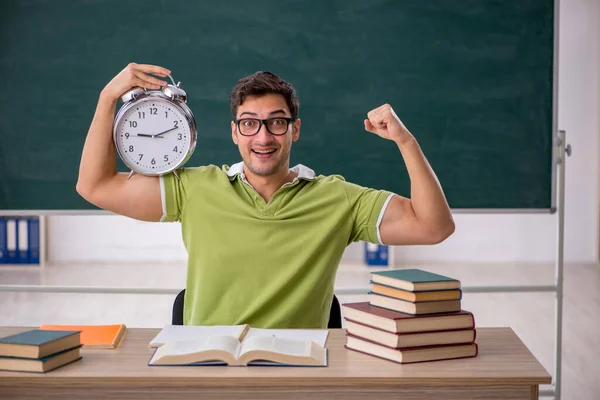 Young student in the classroom in time management concept