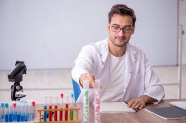 Young chemist in front of white board