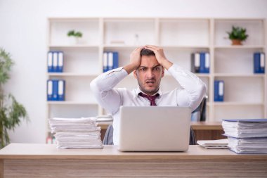 Genç işadamı işyerinde oturuyor.