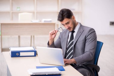 Genç işadamı işyerinde oturuyor.