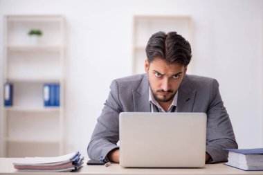 Genç işadamı işyerinde oturuyor.