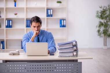 Genç işadamı ve işyerinde çok fazla iş var.