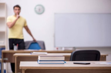 Young student teacher sitting in the classroom