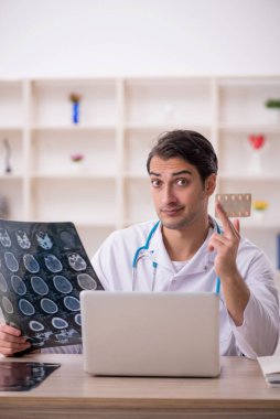 Genç erkek doktor radyoloji uzmanı hastanede çalışıyor.