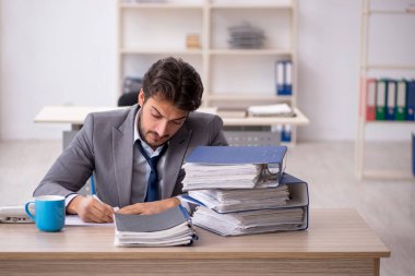 Genç işadamı ve ofiste çok fazla iş var.