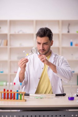 Young chemist sitting at the lab