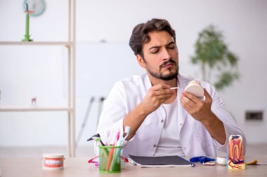 Klinikte çalışan genç bir dişçi.