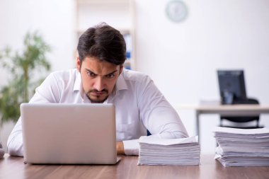 Genç işadamı ve ofiste çok fazla iş var.