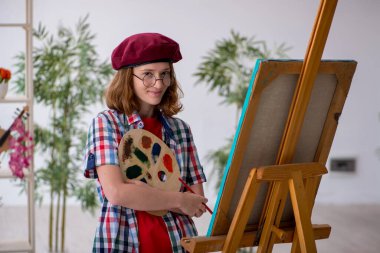 Genç kız öğrenci evde resim yapmaktan hoşlanıyor.