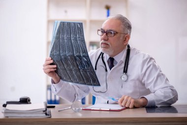 Klinikte çalışan yaşlı bir radyolog.