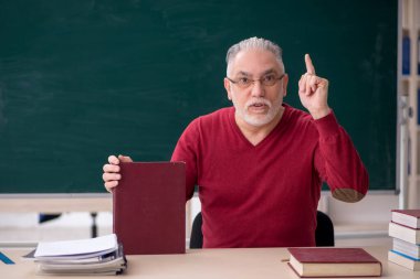 Old teacher sitting in the classroom