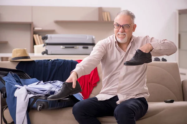 Aged man preparing for trip at home
