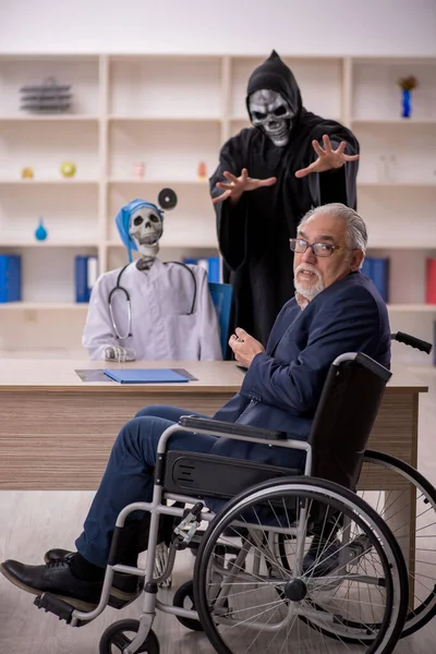 Tekerlekli Sandalyedeki Yaşlı Hasta Iki Şeytan Doktoru Ziyaret Ediyor — Stok fotoğraf