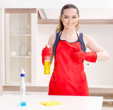 The young beautiful woman cleaning apartment