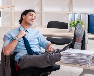 The young man employee with boxes in the office