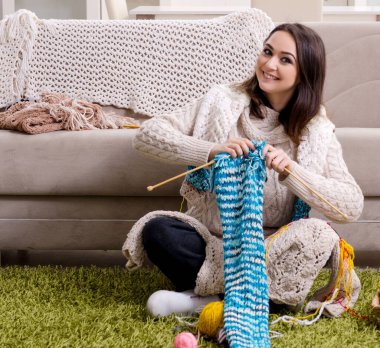 Evde örgü ören genç ve güzel kadın.