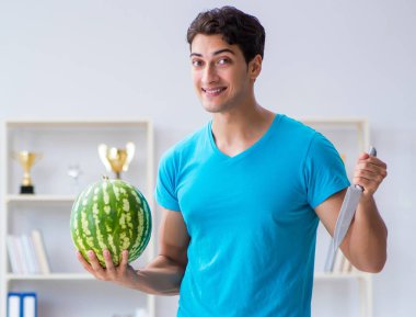 Evde karpuz yiyen adam.