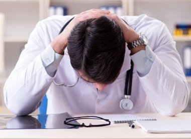 Ofiste oturan genç doktor.