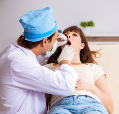 Erkek doktor otolargolog olan genç kadın.
