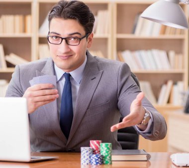 İşadamı iş yerinde kumar oynuyor.